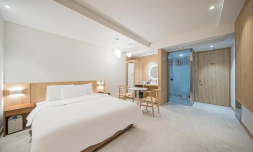 a bedroom with a large white bed and a table at BrownDot Hotel Bong-Duk in Daegu