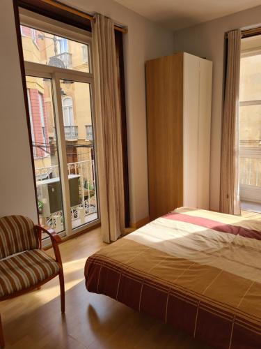 a bedroom with a bed and a large window at Calle Cañón 9 in Cartagena