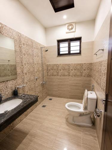 a bathroom with a toilet and a sink and a mirror at 430 Elite Reside in Islamabad