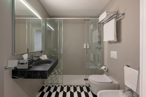 a bathroom with a shower and a toilet and a sink at UNA Hotels Galles Milano in Milan