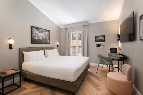 a bedroom with a large white bed and a desk at UNA Hotels Galles Milano in Milan