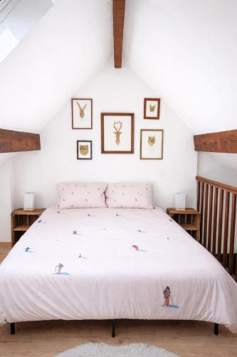 a bedroom with a bed with four pictures on the wall at Le chalet Mountain-style duplex 6 people in Meulan