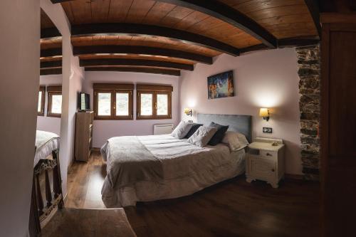 a bedroom with a large bed and a stone wall at El Mirador in Cudillero