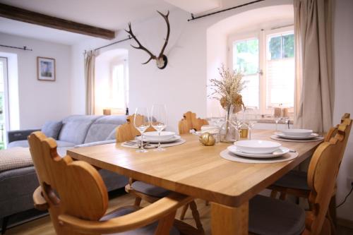 a dining room table with plates and wine glasses at Ferienwohnung Oswald mit Garten im EG in Kochel
