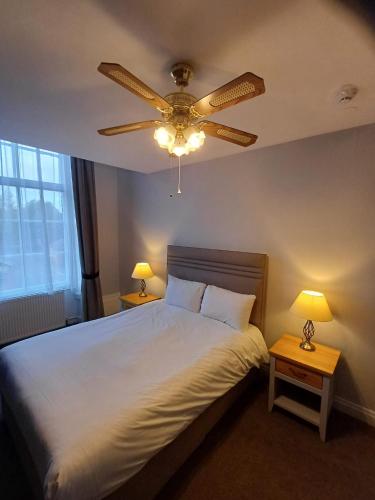 a bedroom with a bed with a ceiling fan at Castle Hotel in Devizes
