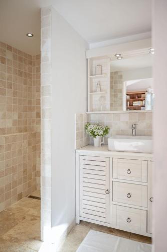 a bathroom with a white sink and a mirror at la maison des Olivettes in Uzès
