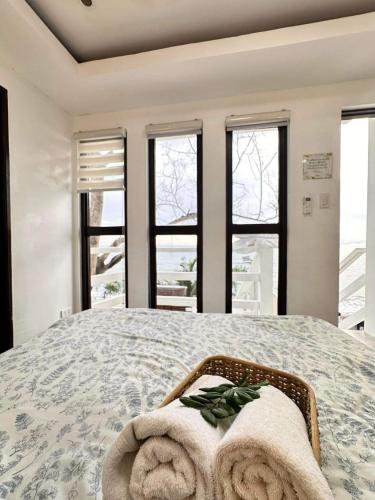 a bedroom with a large bed with towels on it at Villa El Marie in Bacnotan