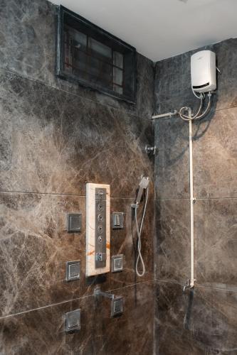 a bathroom with a shower with a window at Prana pulse villa stay gokulam in Mysore