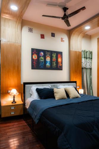 a bedroom with a bed and a ceiling fan at Prana pulse villa stay gokulam in Mysore