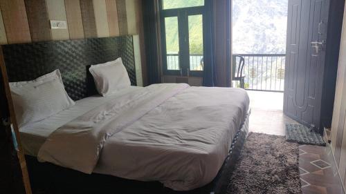 a bed with white sheets and pillows in a bedroom at Rupli homestay in Joshīmath