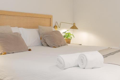 a large white bed with pillows and a plant at Pension Txapitela in Pamplona