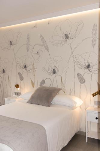 a bedroom with a bed with a flower mural on the wall at Hotel O'Pazo in Vigo
