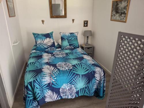 a bedroom with a bed with a blue and white comforter at Chez Teivama in Haapiti