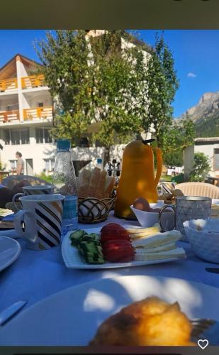 a table with a blue table cloth with food on it at Guesthouse Skender Selimaj in Valbonë