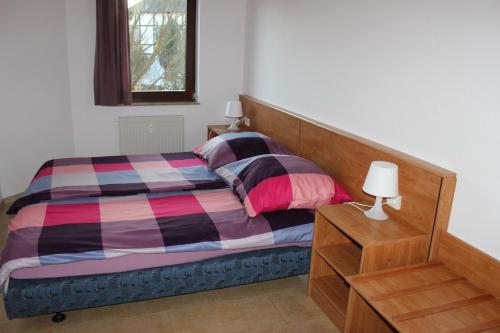シュトロームベルクにあるFerienwohnung Holunderwegのベッドルーム1室(ベッド1台、ドレッサー、ランプ付)