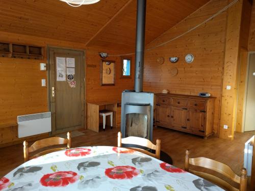 a dining room with a table and a kitchen at Chalet Daria in Prémanon