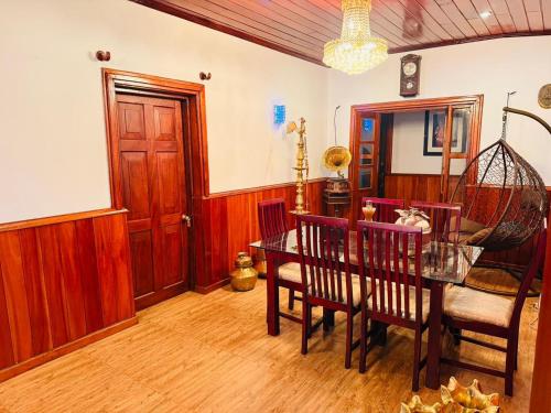 a dining room with a table and chairs and a room with a door at Little England Grand Hotel in Nuwara Eliya