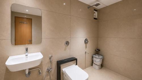a bathroom with a sink and a toilet and a mirror at Hotel Rushikesh inn Dwarka in Dwarka