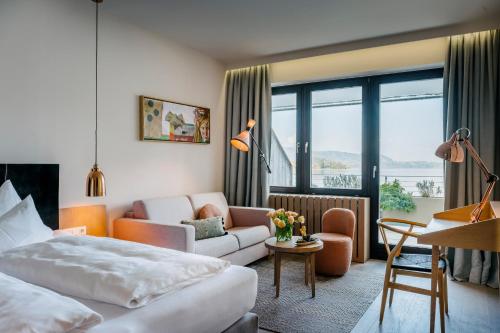a hotel room with a bed and a couch at Das Traunsee - Das Hotel zum See 4 Stern Superior in Traunkirchen