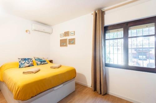a bedroom with a yellow bed and a window at Estudio Las Rotas in Denia
