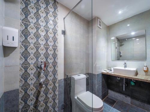 a bathroom with a toilet and a sink at Trevon Hotels & Resorts Candolim Goa in Candolim