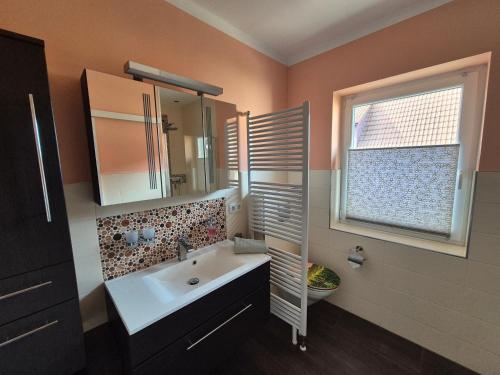 a bathroom with a sink and a mirror and a window at Weinbleibe Weingut Beyer in Dorndorf