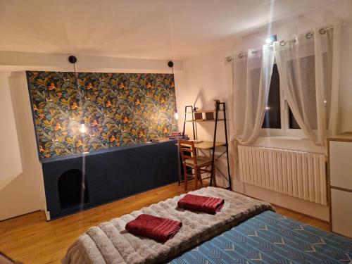 a bedroom with a bed with two red pillows on it at Maison avec jacuzzi proche Rennes jardin calme in Noyal-Châtillon-sur-Seich