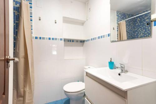 a white bathroom with a toilet and a sink at Estudio Las Rotas in Denia