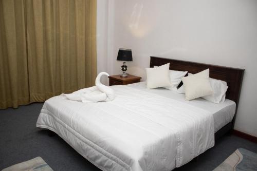 a bedroom with a white bed with a swan on it at Nature Park villa in Arambegama