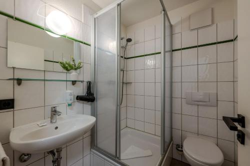 a bathroom with a shower and a sink and a toilet at Johouse Zingst Johouse Zimmer 06 in Zingst