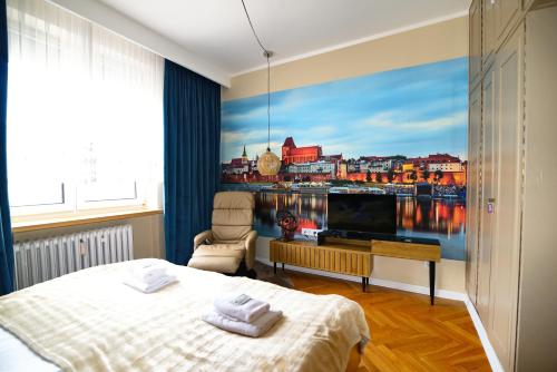 a bedroom with a large painting of a city at City Stay Kaszownik AC Progres in Toruń