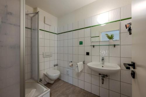 a white bathroom with a sink and a toilet at Johouse Zingst Johouse Zimmer 04 in Zingst
