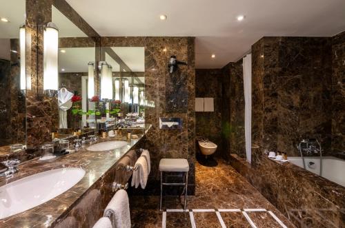 a bathroom with two sinks and a large mirror at Warwick Brussels Grand-Place in Brussels