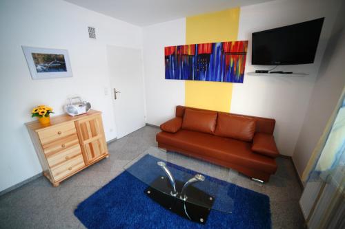 a living room with a couch and a tv at Domki Cztery Pory Roku in Czchów