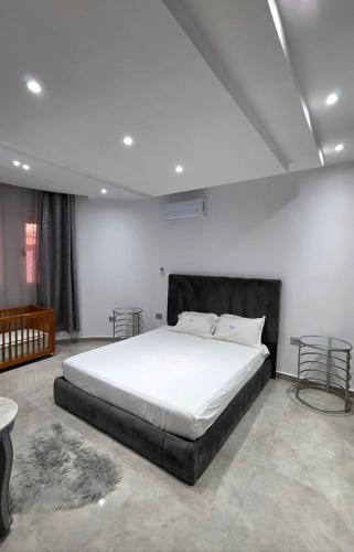 a bedroom with a large white bed with two tables at Luxury Prestige Villa in Midoun