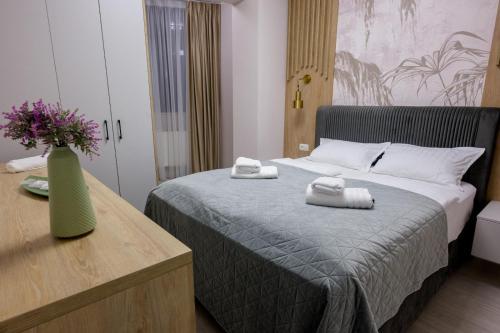 a bedroom with a bed with towels on it at Apart Hotel Nordic Residence 16H in Suceava