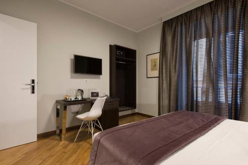 a bedroom with a desk and a bed and a chair at Vittoriano Suite in Rome