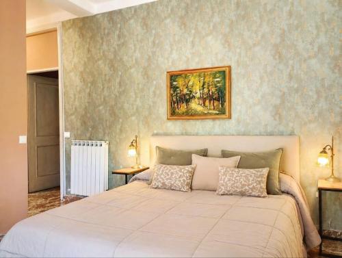 a bedroom with a large bed and a painting on the wall at FalcoBianco GuestHouse in Montefalco