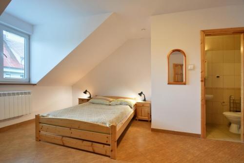 a bedroom with a bed and a sink and a toilet at Agroturystyka Nad Hańcza in Błaskowizna