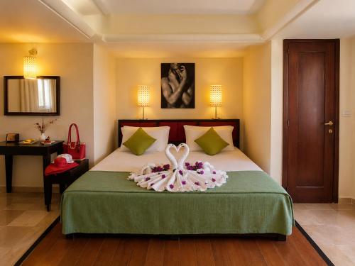 a bedroom with a bed with a flower on it at Hotiday Torre Santo Stefano Resort in Otranto