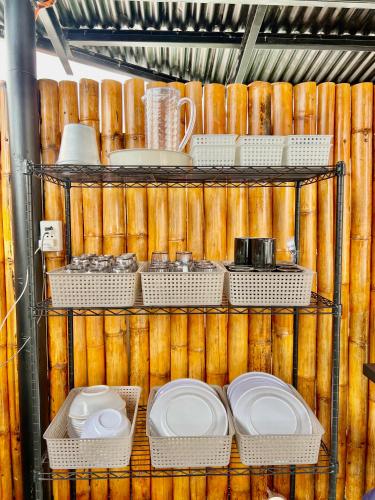 a shelf with plates and utensils in a kitchen at Stayhere Boracay Hostel in Boracay