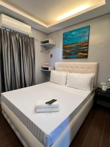 a bedroom with a bed with a book on it at Stayhere Boracay Hostel in Boracay