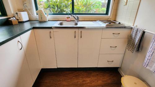a small kitchen with a sink and a window at Aroa Kainga Bungalows and Apartment in Rarotonga