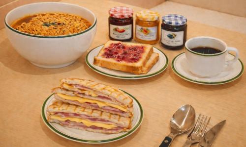 a table with plates of food and a cup of coffee at Cheonan Asan Rosy Hotel in Asan