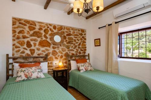 two beds in a room with a stone wall at CANA MARINA Family Friendly in Santa Eularia des Riu