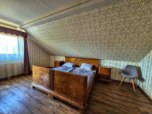 a bedroom with a wooden bed and a chair at Sziget Apartman in Pócsmegyer