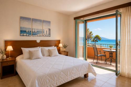 a bedroom with a bed and a view of the ocean at Makis Inn Resort in Thermisía