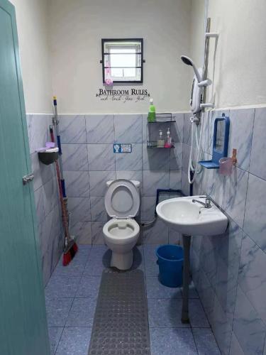 a bathroom with a toilet and a sink at KRPV Homestay in Tambunan