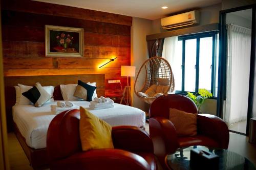 a bedroom with a bed and chairs and a window at Letana Hotel in Bang Phli