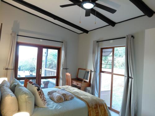 a bedroom with a bed with a ceiling fan at Sickle Bush Da Gama Lake in White River